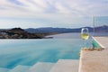 .a glass of white wine with shell beads is located on the edge of the pool stairs Royalty Free Stock Photo