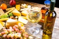 Glass of White Wine on Table with Various Cheeses Royalty Free Stock Photo
