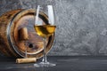 Glass with white wine for tasting and wooden barrel with corkscrew in dark cellar Royalty Free Stock Photo