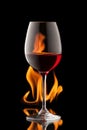 Glass of wine on black background with fire splash Royalty Free Stock Photo