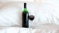 A glass of wine and wine bottle in the bed Royalty Free Stock Photo