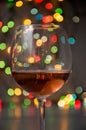 Glass of wine on garland christmas colourful background Royalty Free Stock Photo