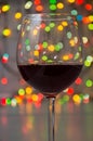 Glass of wine on garland christmas colourful background Royalty Free Stock Photo