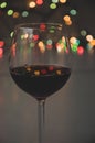 Glass of wine on garland christmas colourful background Royalty Free Stock Photo