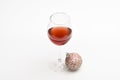 Glass with wine and christmas decoration. Christmas menu concept. Wineglass with red liquid or wine and christmas ball Royalty Free Stock Photo