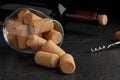 Glass with wine corks, bottle and corkscrew on dark table, closeup Royalty Free Stock Photo