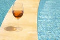 Glass wine glass on the edge of a swimming pool. Rose wine in a glass goblet. Money abundance concept Royalty Free Stock Photo