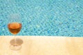 Glass wine glass on the edge of a swimming pool. Rose wine in a glass goblet. Money abundance concept Royalty Free Stock Photo