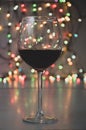 Glass of wine on garland christmas colourful background Royalty Free Stock Photo