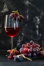 Glass of wine with grapes on a black wooden stand Royalty Free Stock Photo
