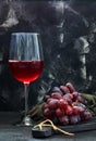 Glass of wine with grapes on a black wooden stand Royalty Free Stock Photo