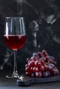 Glass of wine with grapes on a black wooden stand Royalty Free Stock Photo
