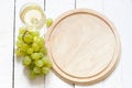 Glass of wine and grapes with empty cutting board