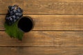 Glass with wine grapes and vine leaf on wooden background. Top view with copy space Royalty Free Stock Photo