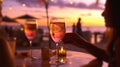 glass of wine in hand on evening pink sunset summer beach restaurant beach , romantic couple silhouette