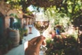 Glass of wine in hand. A glass of young fresh rose wine against the backdrop of a summer cafe in a Mediterranean seaside Royalty Free Stock Photo