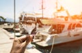 Glass of wine in hand. A glass of white wine against the backdrop of the Mediterranean sea and the port with yachts in a Royalty Free Stock Photo