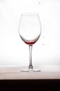 A glass of wine with a little bit of wine and a few drops of red on the outside Royalty Free Stock Photo