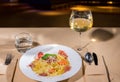 Glass with wine near tasty spaghetti pasta in white plate in a r Royalty Free Stock Photo