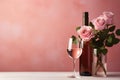 glass of wine with pink roses flowers in vase and bottle on pink background with copy space, romantic template design Royalty Free Stock Photo
