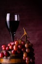 A glass of wine and red grapes on barrel Royalty Free Stock Photo