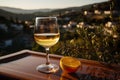 glass of wine on a rustic table, set against a beautiful rural backdrop.