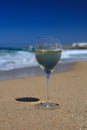 Glass of wine on the sand on the beach against a blue sky Royalty Free Stock Photo