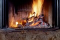 A glass of wine stands by a blazing fireplace close-up Royalty Free Stock Photo