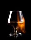 Glass of wisky in fire flame on black background Royalty Free Stock Photo