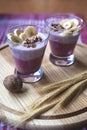 A glass of yogurt with blueberries, cereals, banana and walnuts