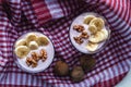 A glass of yogurt with blueberries, cereals, banana and walnuts. Top view