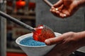 Glassblower applying frit to molten glass