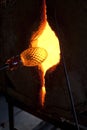 Glassblower shaping molten glass in a kiln Royalty Free Stock Photo