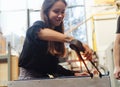 A glassblower student tries to make a flower out of glass Royalty Free Stock Photo