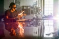 Glassblowing Young Man Working on a Torch Flame with Glass Tubes