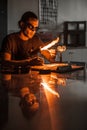 Glassblowing Young Man Working on a Torch Flame with Glass Tubes