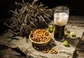 Glasse beer with wheat and hops, basket of pretzels Royalty Free Stock Photo