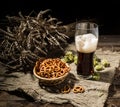 Glasse beer with wheat and hops, basket of pretzels Royalty Free Stock Photo