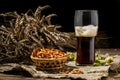 Glasse beer with wheat and hops, basket of pretzels Royalty Free Stock Photo