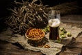 Glasse beer with wheat and hops, basket of pretzels Royalty Free Stock Photo