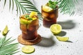 Glasses of Alcohol cocktail cuba libre with rum, cola, mint and lime in the glass on a light background, place for text Royalty Free Stock Photo