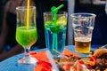 Glasses with alcoholic cocktails and a glass with beer on the table outdoors Royalty Free Stock Photo