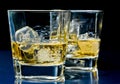 Glasses of alcoholic drink with ice on blue light Royalty Free Stock Photo