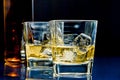 Glasses of alcoholic drink with ice on blue light Royalty Free Stock Photo