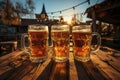 Glasses with amber beer stand on a wooden table in the sun.