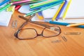 Glasses on the background of colored pencils and paper. Royalty Free Stock Photo