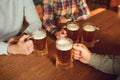 Glasses with beer in the hands of people in a bar. Royalty Free Stock Photo