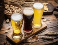 Glasses of beer and snacks on the wooden table.