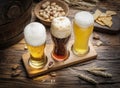 Glasses of beer and snacks on the wooden table. Royalty Free Stock Photo