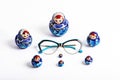 Glasses in a blue frame and blue nesting dolls on a white background